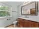 Bathroom with a wooden vanity, neutral countertops, and framed mirror at 1705 Bridgeport Dr, Raleigh, NC 27615