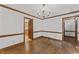 Bright dining room featuring hardwood floors, a chandelier, and views into the kitchen at 1705 Bridgeport Dr, Raleigh, NC 27615