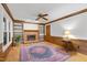 Cozy living room featuring a brick fireplace, built-in shelving, wood trim, and a colorful area rug at 1705 Bridgeport Dr, Raleigh, NC 27615