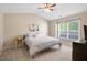 Bright bedroom with a ceiling fan, large window letting in natural light, and neutral color palette at 1826 Heisser Ln, Fuquay Varina, NC 27526