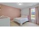 A cozy bedroom with a pretty pink accent wall and a bright window for a peaceful atmosphere at 1826 Heisser Ln, Fuquay Varina, NC 27526