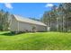 Exterior view of a home with a grill on the patio and a large backyard with a storage shed at 1840 Willie Pace Rd, Burlington, NC 27217