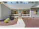 Inviting front porch with white railing, brick base, and stylish front door, complemented by well-maintained landscaping at 1840 Willie Pace Rd, Burlington, NC 27217