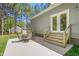 Outdoor patio with seating area, stairs to the main home, and a lush green yard surrounded by trees at 1840 Willie Pace Rd, Burlington, NC 27217
