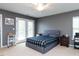 Well-lit bedroom featuring a large bed, neutral walls, double doors, and a ceiling fan at 1909 Whirlaway Ct., Cary, NC 27519