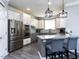 Modern kitchen featuring stainless steel appliances, gray cabinets, and a breakfast bar at 1909 Whirlaway Ct., Cary, NC 27519