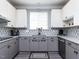 Updated kitchen with gray and white cabinetry, modern backsplash, and stainless dishwasher at 1909 Whirlaway Ct., Cary, NC 27519