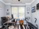 Bright office space with neutral walls, crown moulding, large window with bench seat, and an exercise machine at 1909 Whirlaway Ct., Cary, NC 27519