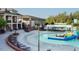 Stunning community pool area with lounge chairs, a slide, and elegant clubhouse architecture at 1909 Whirlaway Ct., Cary, NC 27519