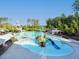 Aerial view of a vibrant community pool area with slides, lounge chairs, and clear blue water at 1909 Whirlaway Ct., Cary, NC 27519