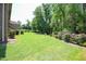 Lush backyard with manicured lawn, mature trees, and beautiful landscaping at 197 W Paige Wynd Dr, Angier, NC 27501