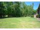 Spacious backyard featuring a well-maintained lawn and mature trees along the perimeter at 197 W Paige Wynd Dr, Angier, NC 27501
