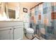 Well-lit bathroom featuring a vanity, toilet, and shower with a patterned shower curtain at 197 W Paige Wynd Dr, Angier, NC 27501