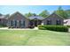 Charming brick home featuring a manicured lawn and lush landscaping at 197 W Paige Wynd Dr, Angier, NC 27501