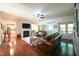 Open living room with hardwood floors, leather couches, a fireplace, ceiling fan, and natural light at 197 W Paige Wynd Dr, Angier, NC 27501