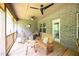 Inviting screened porch with rocking chairs, wooden benches, and a rustic wooden table at 197 W Paige Wynd Dr, Angier, NC 27501