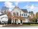 Inviting home with neat front yard landscaping and traditional facade featuring complementary green shutters and a peaked roof at 2014 Silky Dogwood Trl, Apex, NC 27502