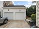 Two car garage with white doors and two outdoor lights at 2014 Silky Dogwood Trl, Apex, NC 27502
