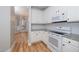Charming kitchen with white cabinets, granite countertops, stainless steel appliances, and hardwood floors at 2014 Silky Dogwood Trl, Apex, NC 27502