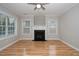 Cozy living room with hardwood floors, a ceiling fan and a fireplace, creating a warm, inviting space at 2014 Silky Dogwood Trl, Apex, NC 27502