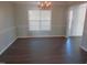 Dining room features hardwood floors, a hanging light fixture, and large window at 202 Redstone Ct, Gibsonville, NC 27249