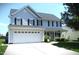 Charming two-story home with a large front lawn and an attached two-car garage at 202 Redstone Ct, Gibsonville, NC 27249
