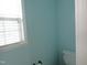 Bright half bathroom featuring a window and fresh, light blue paint at 202 Redstone Ct, Gibsonville, NC 27249