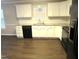 Well-lit kitchen featuring white cabinetry, granite countertops, and modern appliances on new flooring at 202 Redstone Ct, Gibsonville, NC 27249