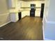 Spacious kitchen with white cabinets, stainless steel appliances, and new wood flooring, great for cooking at 202 Redstone Ct, Gibsonville, NC 27249