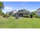 Well-manicured lawn with a fire pit and a screened-in porch creates a relaxing backyard retreat at 2086 Amalfi Pl, Apex, NC 27502