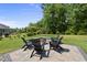 Inviting backyard featuring a stone patio with firepit and Adirondack chairs at 2086 Amalfi Pl, Apex, NC 27502