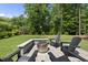 Backyard featuring a firepit surrounded by Adirondack chairs on a stone patio at 2086 Amalfi Pl, Apex, NC 27502