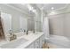 Bright bathroom featuring a double sink vanity and a shower over the tub at 2086 Amalfi Pl, Apex, NC 27502