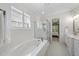 Bright bathroom with a soaking tub and glass enclosed shower, plus patterned floors at 2086 Amalfi Pl, Apex, NC 27502