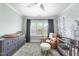 Light filled Bedroom with dark-tone dresser, chair, and mountains on the wall at 2086 Amalfi Pl, Apex, NC 27502