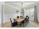 Dining room with a wooden table, black chairs, designer wallpaper, and window for light at 2086 Amalfi Pl, Apex, NC 27502