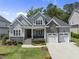 Charming home with stone accents, a two-car garage, covered porch, and well-manicured lawn at 2086 Amalfi Pl, Apex, NC 27502