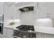 Close-up of kitchen area showcasing white cabinets, stainless steel appliances, and subway tile backsplash at 2086 Amalfi Pl, Apex, NC 27502