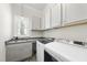Bright laundry room with ample counter space, washer, dryer, and storage cabinets at 2086 Amalfi Pl, Apex, NC 27502