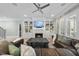 Light-filled living room with built-in shelving, fireplace, modern ceiling fan, and comfortable leather seating at 2086 Amalfi Pl, Apex, NC 27502