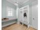 Mudroom with storage lockers, a bench, a desk, hardwood floors, and a window for natural light at 2086 Amalfi Pl, Apex, NC 27502