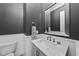 Elegant powder room with a marble countertop, stylish fixtures, and wainscoting at 2086 Amalfi Pl, Apex, NC 27502