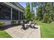 Beautifully landscaped backyard with a stone patio and comfortable seating around a firepit at 209 Preston Retreat Ln, Cary, NC 27513