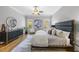 Bedroom features wood floors, a modern ceiling fan and a dresser for storage at 209 Preston Retreat Ln, Cary, NC 27513