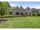 Inviting home with lush green lawn and manicured landscaping, with a mix of stone and siding facade at 209 Preston Retreat Ln, Cary, NC 27513