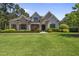 Beautiful two-story home featuring stone accents, lush landscaping, and a well-manicured lawn at 209 Preston Retreat Ln, Cary, NC 27513