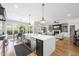 Open concept kitchen with oversized island and stainless steel appliances flows into the living room at 209 Preston Retreat Ln, Cary, NC 27513