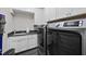 Well-organized laundry room with modern washer and dryer units and storage space at 209 Preston Retreat Ln, Cary, NC 27513