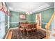 Elegant dining room with green walls, hardwood floors, and a view into the kitchen at 210 Presidents Walk Ln, Cary, NC 27519
