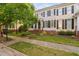 Charming townhouse with brick foundation, landscaped lawn, black shutters, and a tree-lined sidewalk at 210 Presidents Walk Ln, Cary, NC 27519